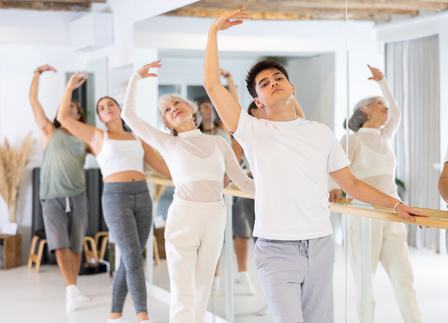 Diligent young man doing choreography at ballet barre